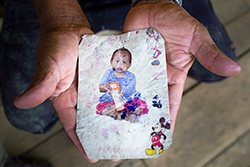 Alfonso muestra la foto de su difunta nieta Dallana que encontró entre los escombros de su casa en Nankints, ahora un campamento minero. / Edu León Una foto de Dallana en las manos de su abuelo Alfonso. Foto: Edu León